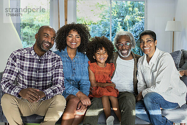 Glückliche Familie mit mehreren Generationen sitzt im Wohnzimmer