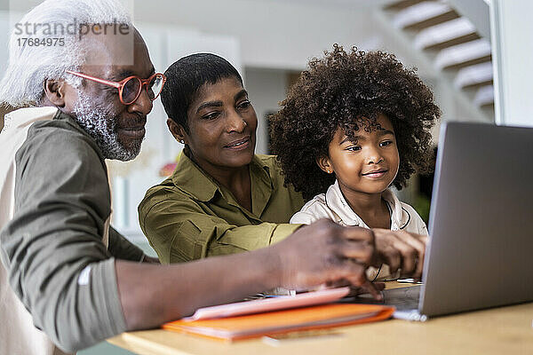 Großeltern mit Enkelin  die Laptop benutzen