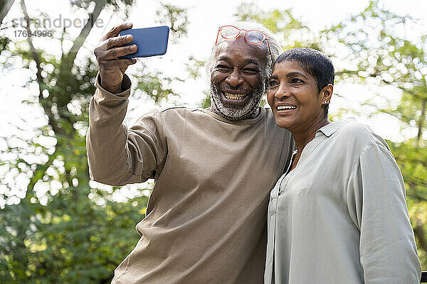 Lächelndes Paar macht Selfie mit Smartphone