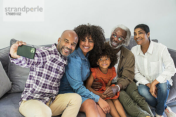 Glückliche Familie mit mehreren Generationen  die ein Selfie im Wohnzimmer macht