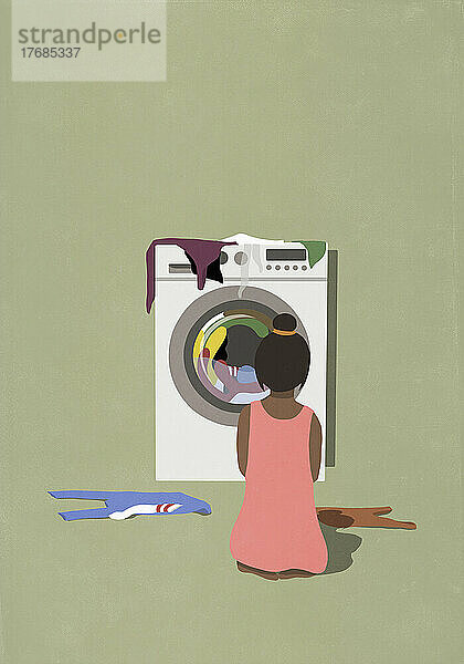 Frau beobachtet das Trocknen von Wäsche im Wäschetrockner