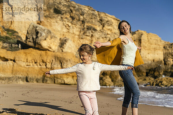 Glückliche Frau mit Tochter genießt den Strand an einem sonnigen Tag