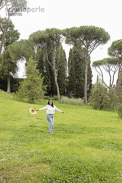 Frau mit Hut genießt das grüne Gras im Park