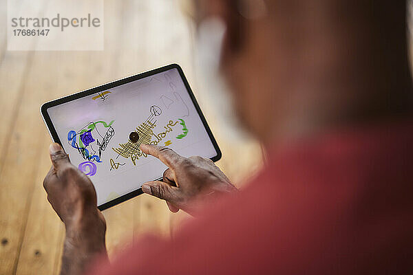 Mann zeichnet zu Hause auf einem Tablet-PC