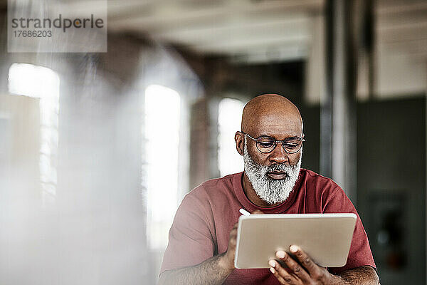 Mann mit Bart benutzt Tablet-PC zu Hause