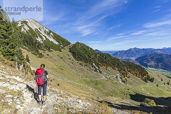 Deutschland  Bayern  Wanderin bewundert die Aussicht auf dem Weg zum Berg Geigelstein