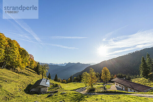 Germany  Bavaria  Sun shining over secluded huts in Chiemgau Alps
