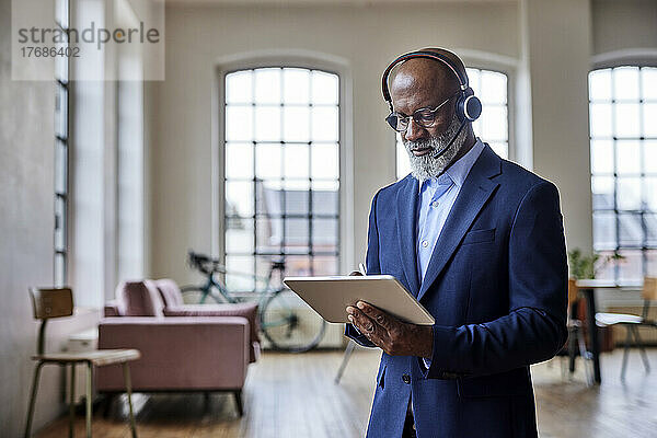 Geschäftsmann mit Headset arbeitet zu Hause am Tablet-Computer