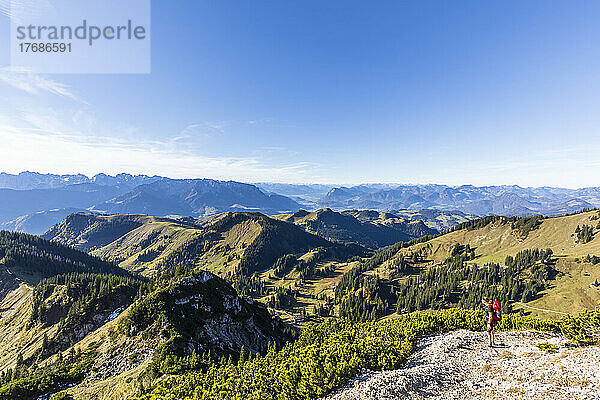 Deutschland  Bayern  Wanderin mit Blick auf die Chiemgauer Alpen auf dem Weg zum Geigelstein