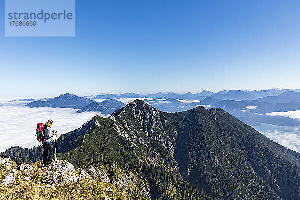 Deutschland  Bayern  Wanderin bewundert die Aussicht vom Berggipfel in den Bayerischen Voralpen