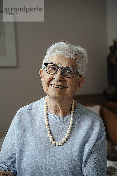 Glückliche ältere Frau  die zu Hause eine Brille trägt
