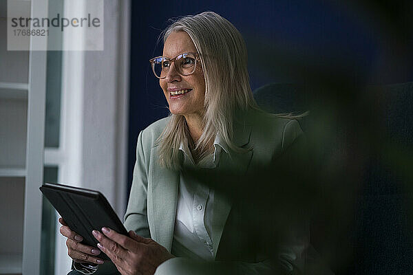Nachdenkliche Geschäftsfrau mit Brille und Tablet-PC