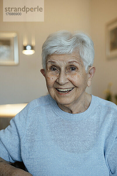 Glückliche ältere Frau mit weißen Haaren zu Hause