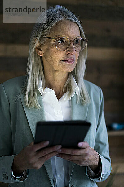 Geschäftsfrau mit Tablet-PC vor der Wand