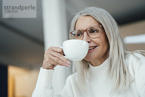 Lächelnde ältere Frau  die Kaffee trinkt