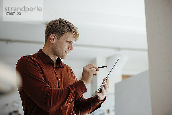 Geschäftsmann hält digitalisierten Stift und Tablet-PC im Büro