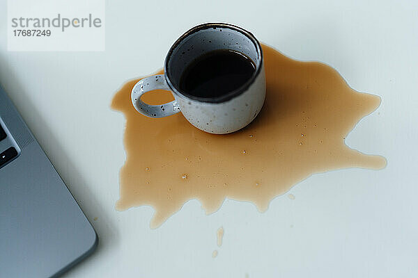 Verschütteter Kaffee vom Laptop auf dem Schreibtisch
