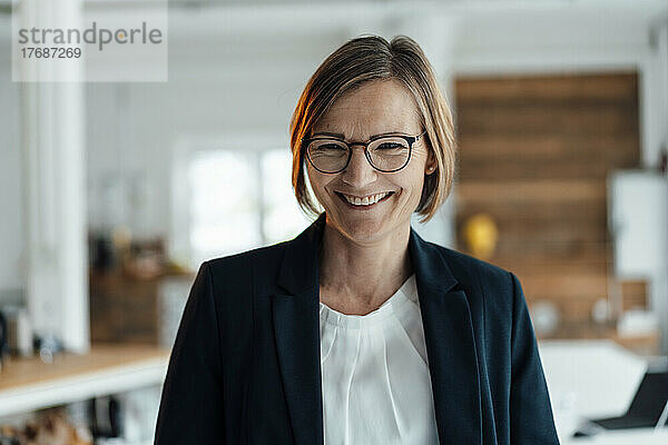 Happy businesswoman wearing eyeglasses in office
