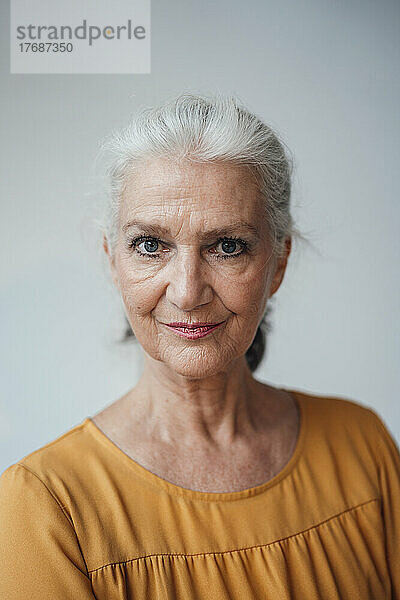 Ältere ältere Frau mit grauen Haaren vor weißem Hintergrund