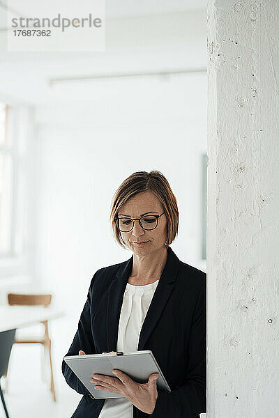 Geschäftsfrau mit Brille und Tablet-PC im Büro