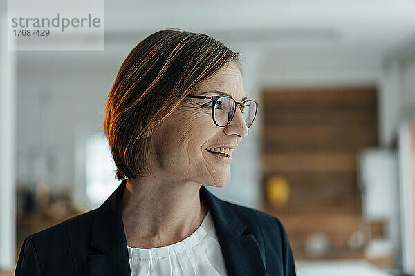 Smiling businesswoman wearing eyeglasses in office