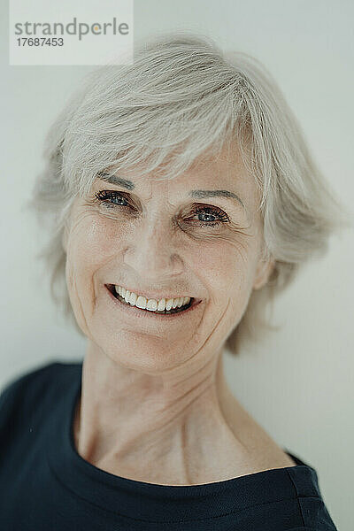 Lächelnde ältere Frau vor weißem Hintergrund