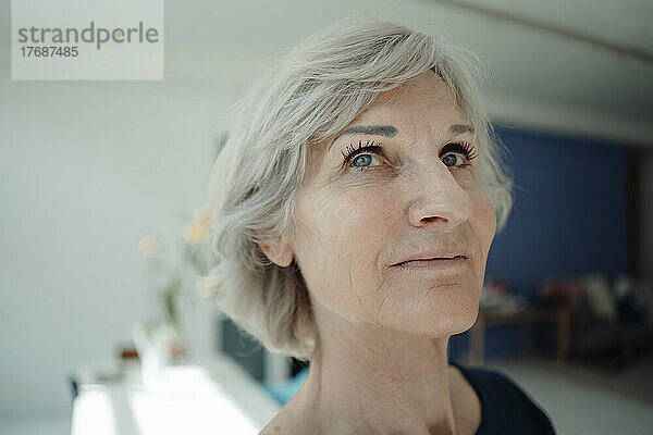 Lächelnde ältere Geschäftsfrau mit grauen Haaren im Büro