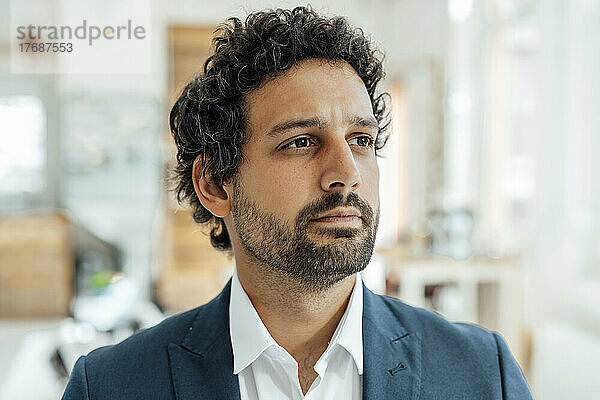 Thoughtful businessman standing in office