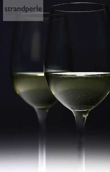 White wine glasses against black background