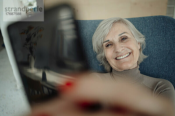 Lächelnde ältere Frau  die ein Selfie mit dem Smartphone macht