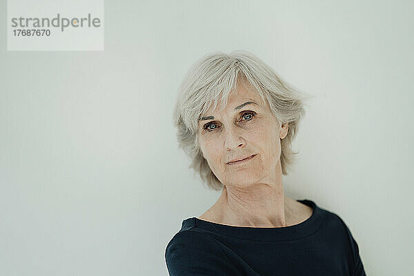 Ältere ältere Frau mit grauen Haaren vor weißem Hintergrund