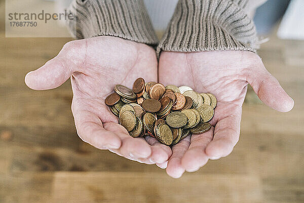 Close up of cupped hands with small change