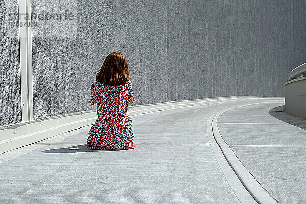 Traurige einsame Frau sitzt auf dem Fußweg