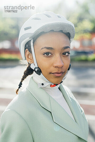 Selbstbewusste Geschäftsfrau mit Fahrradhelm