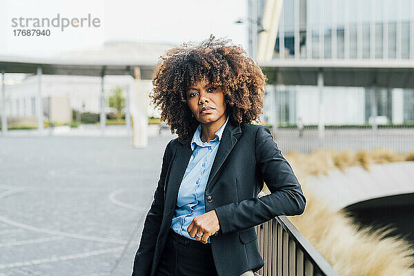 Selbstbewusste Afro-Geschäftsfrau steht am Geländer