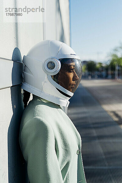 Geschäftsfrau trägt an einem sonnigen Tag einen Weltraumhelm