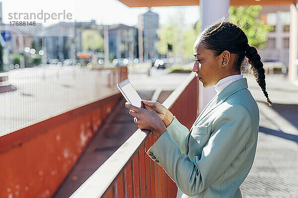 Geschäftsfrau benutzt Tablet-Computer auf Fußweg