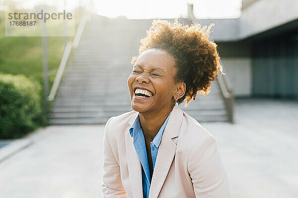 Afro-Geschäftsfrau lacht vor der Treppe