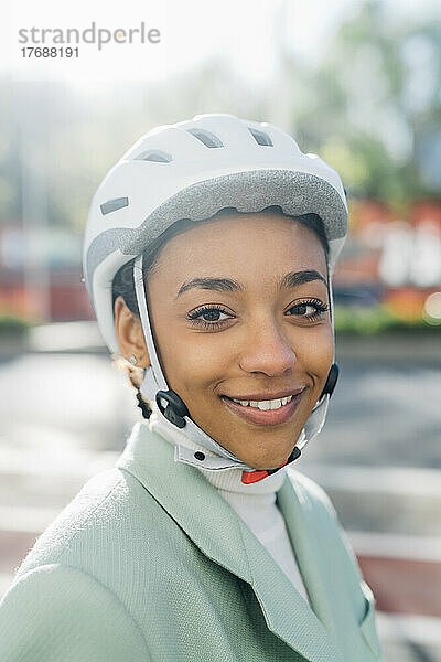 Lächelnde Geschäftsfrau mit Fahrradhelm