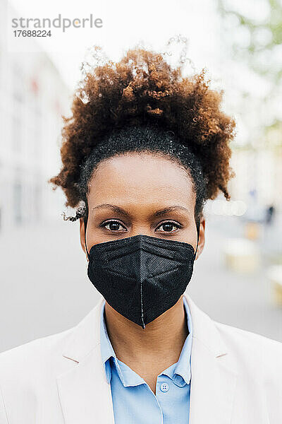 Afro-Geschäftsfrau trägt schützende Gesichtsmaske gegen Smog