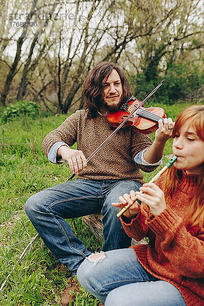 Mann und Frau proben mit Musikinstrumenten im Feld