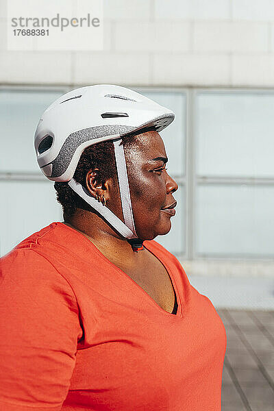 Mature woman wearing cycling helmet on sunny day