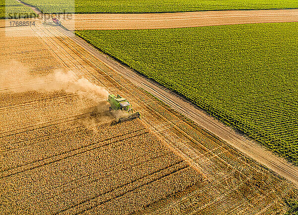 Aerial view of combine harvester at farm harvesting wheat crop field
