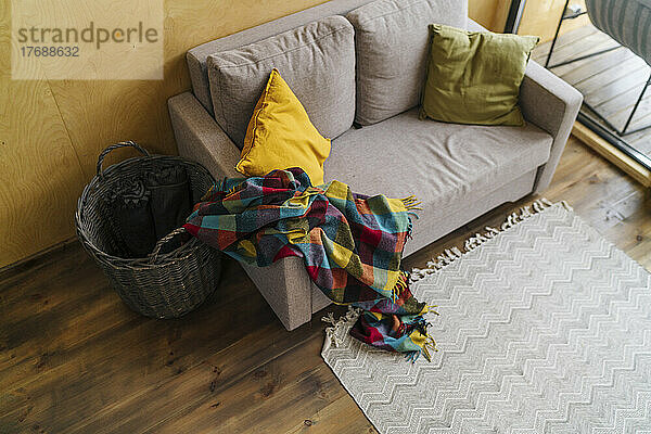 Colorful blanket on empty sofa