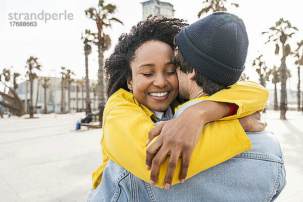 Lächelnde Afro-Frau umarmt Mann