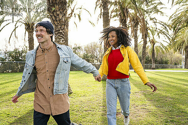 Happy man with girlfriend running at park