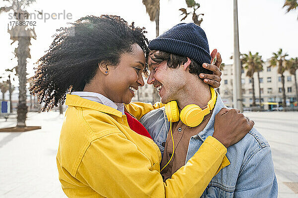 Lächelnde Frau mit Afro-Frisur genießt Freizeit mit Mann