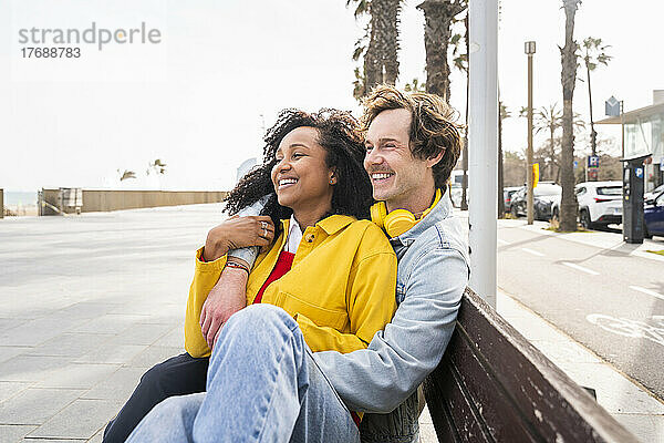 Glückliches Paar sitzt auf einer Holzbank am Fußweg