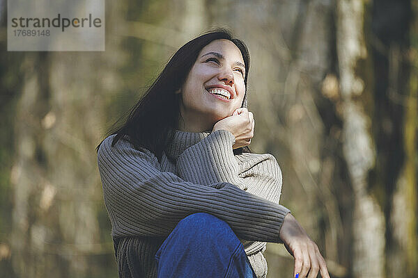 Cheerful young beautiful woman in forest on sunny day