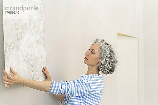 Frau mit Tapetenmuster auf weißer Wand